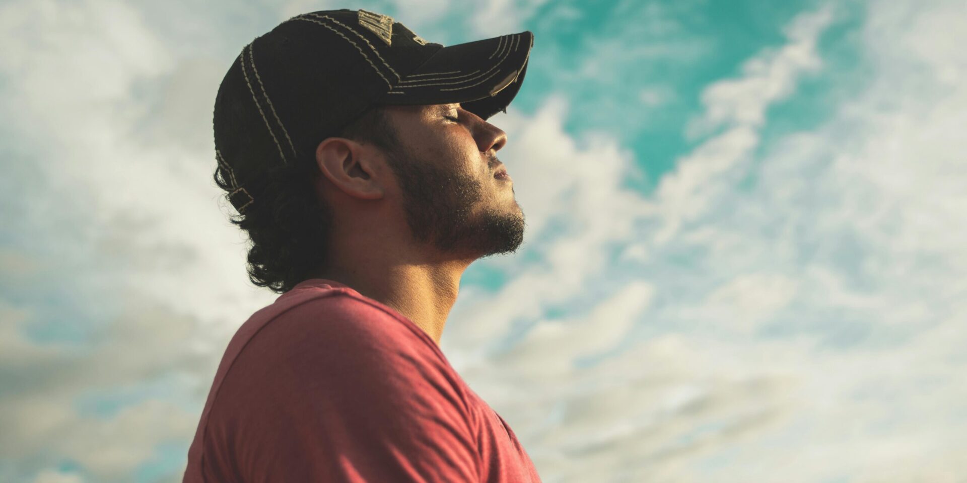 Man sitting with eyes closed, quietly reflecting, symbolizing a personal moment of clarity before recovery—not a dramatic rock bottom.
